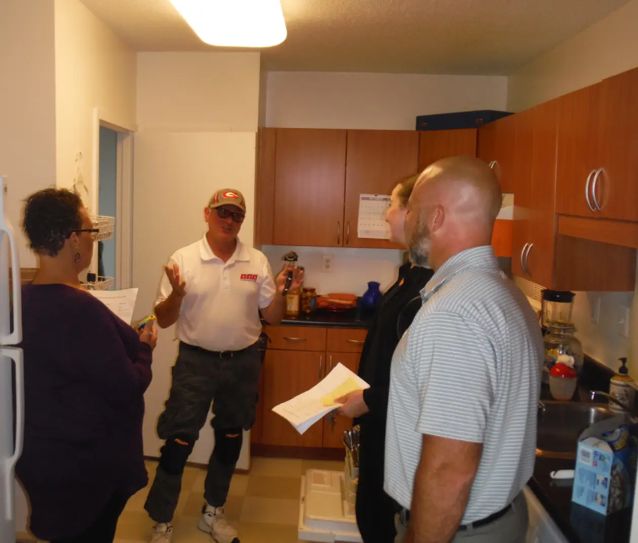 A group of people standing in the kitchen