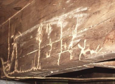 A close up of some writing on the side of a rock
