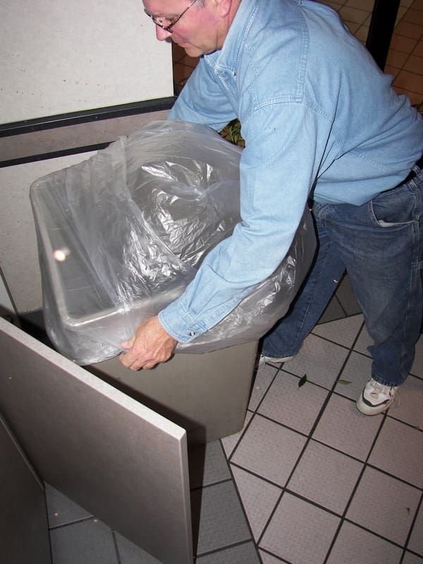 A man is moving a sink in the kitchen.