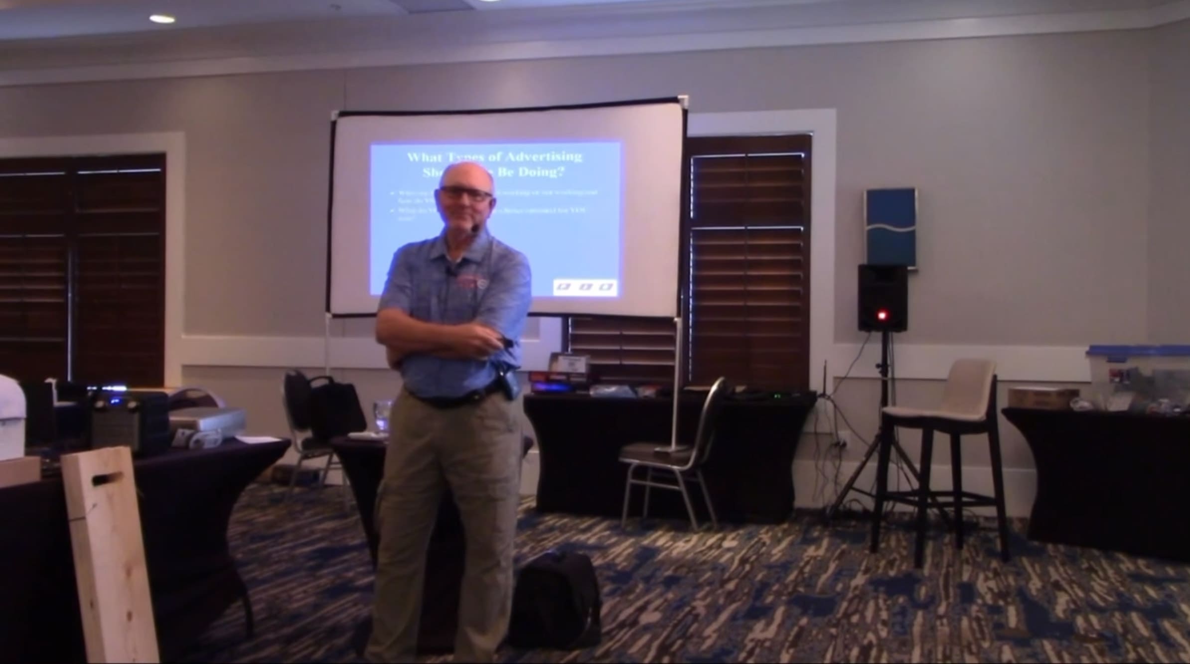 A man standing in front of a projector screen.
