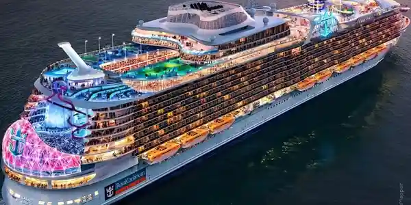 A large cruise ship with many decks and lights.