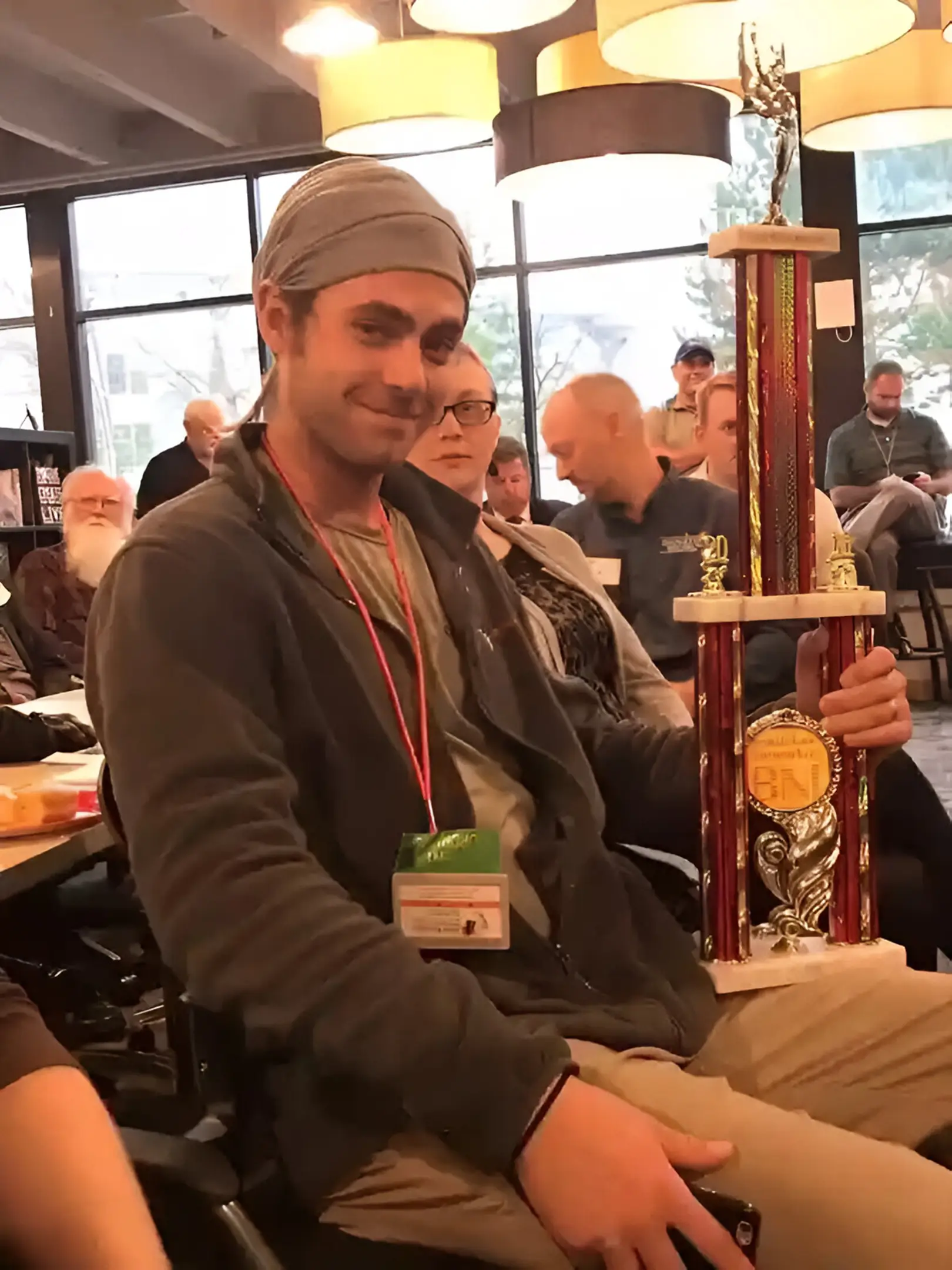 Person holding a large trophy indoors.