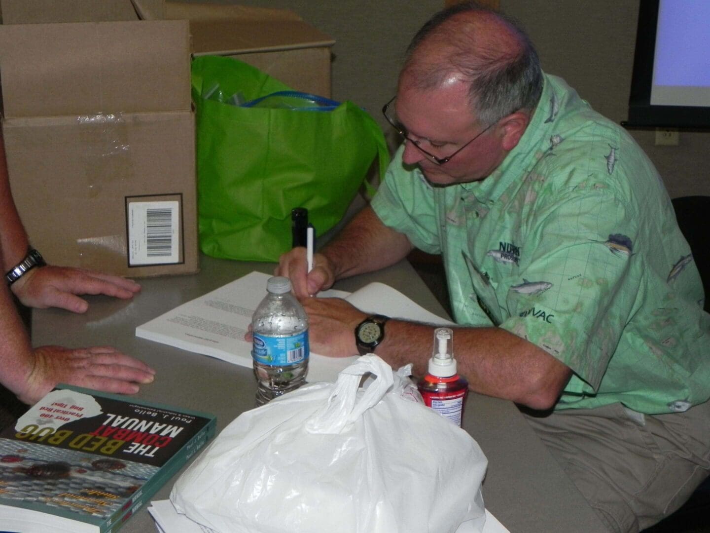 Man signing papers at a table.
