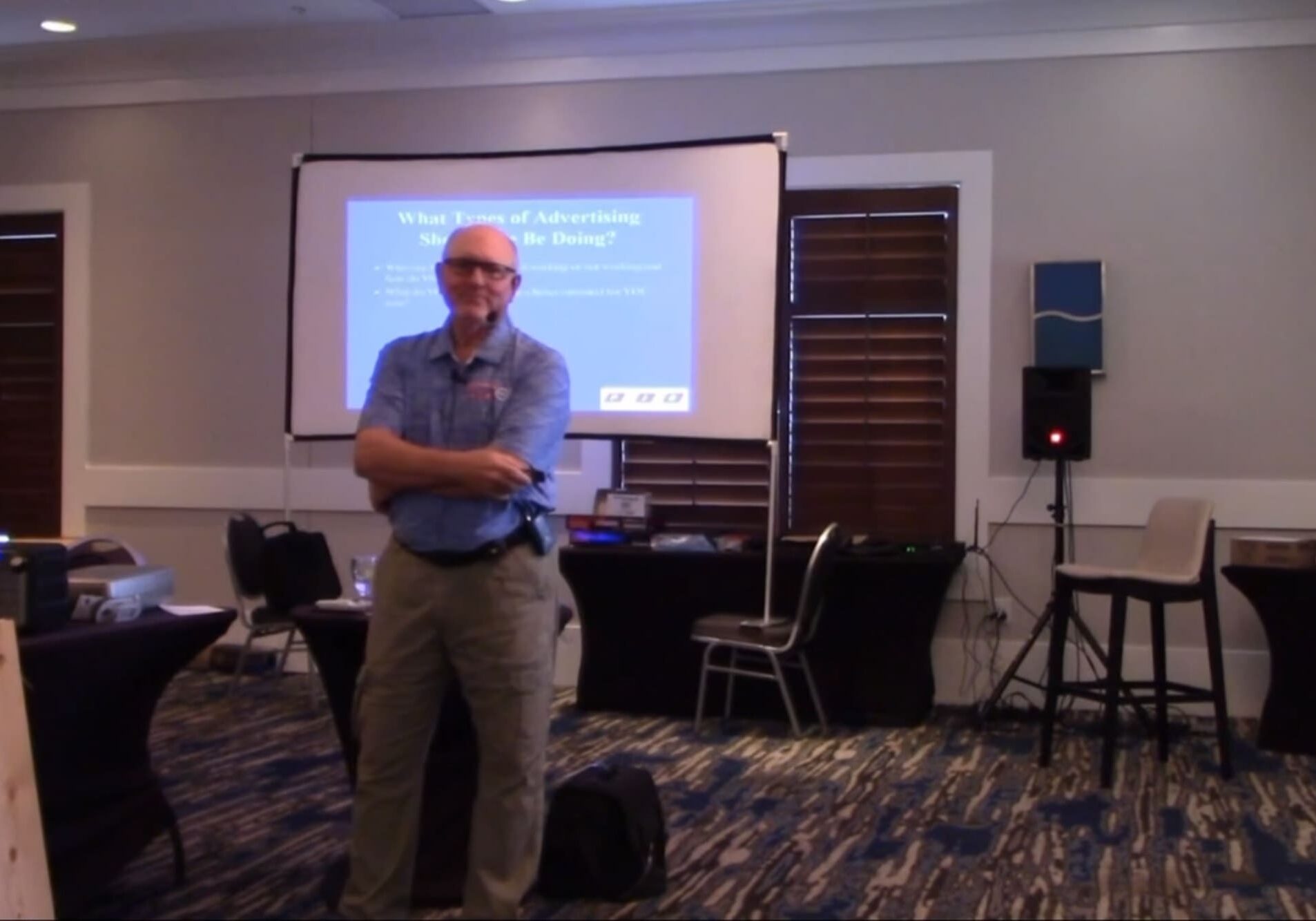 A man standing in front of a projector screen.