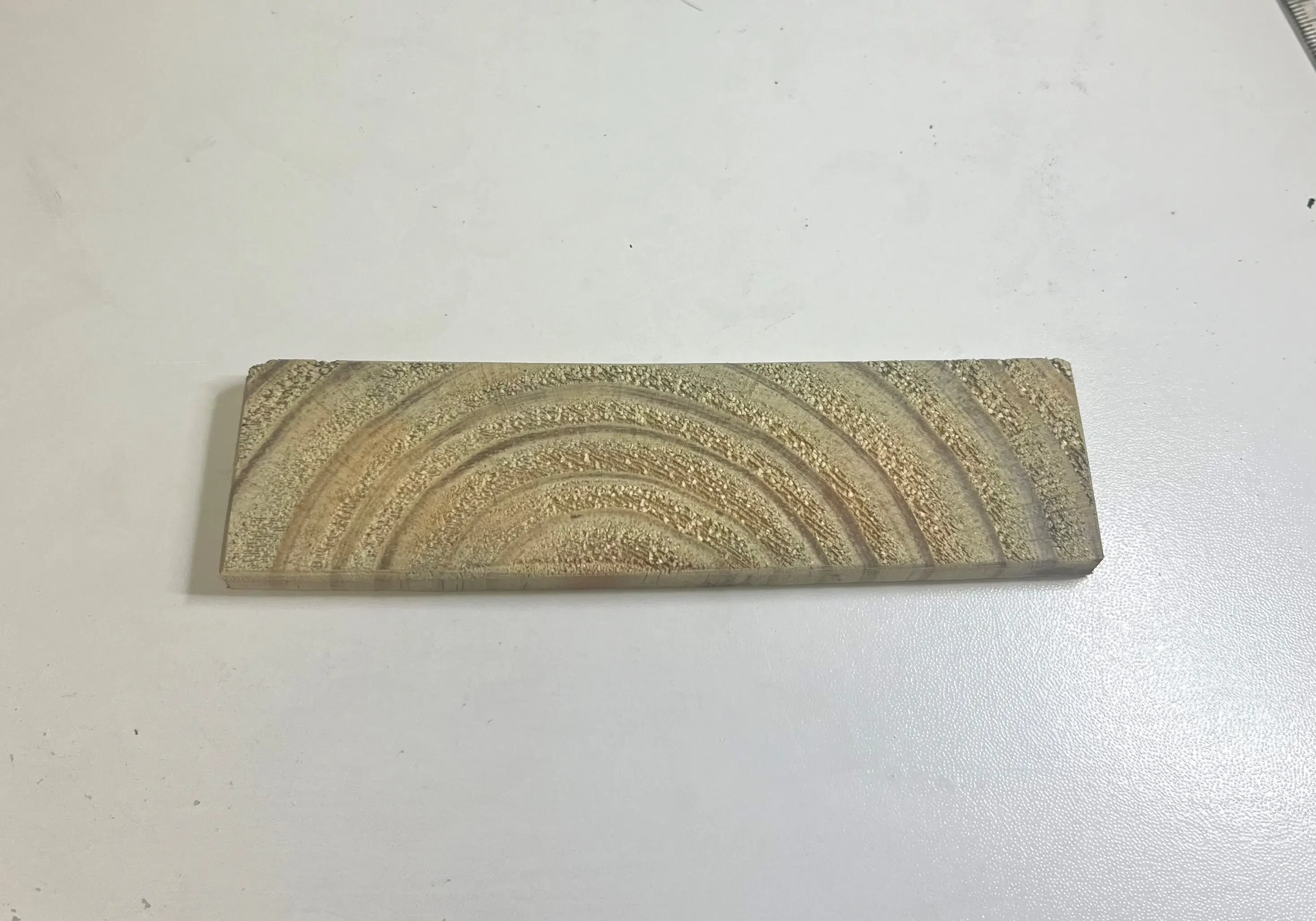 Rectangular stone with curved pattern design.